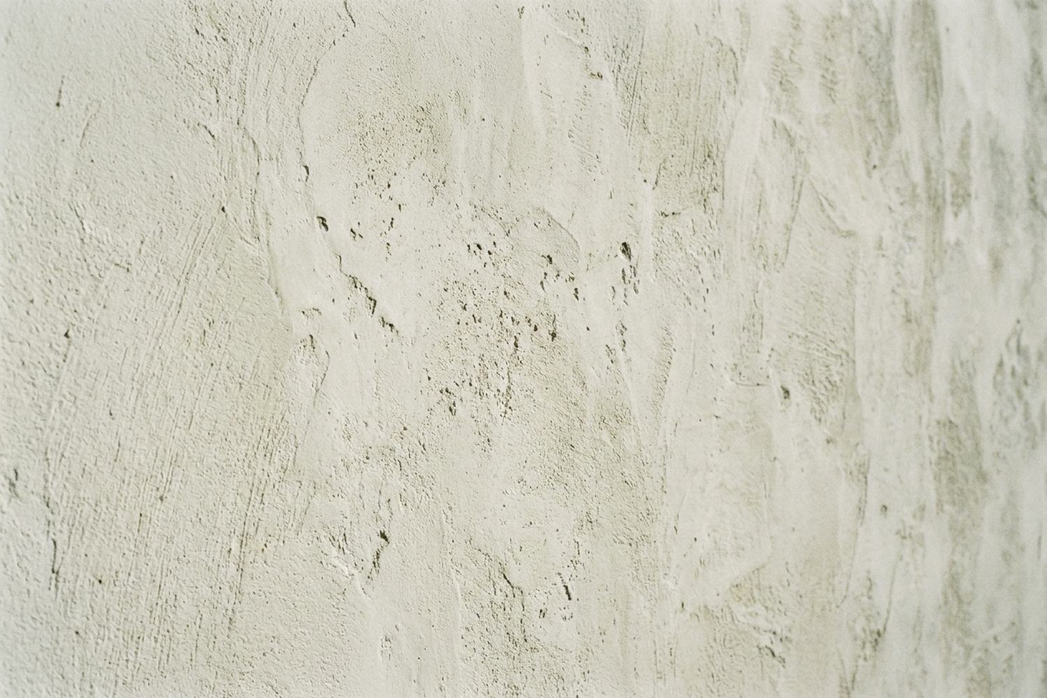 A lime washed wall showing its trowel texture in raking light.